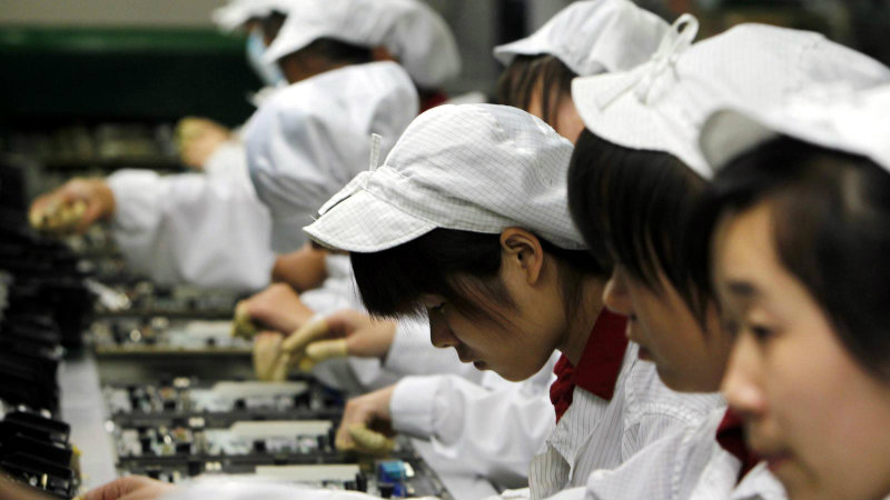 Рабочие на заводе Foxconn | Фото: qz.com